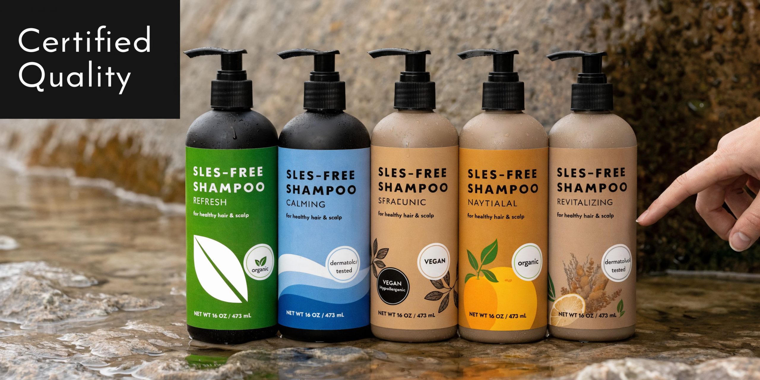 Five bottles of SLES-free shampoo arranged in a row on a wet stone surface outdoors.