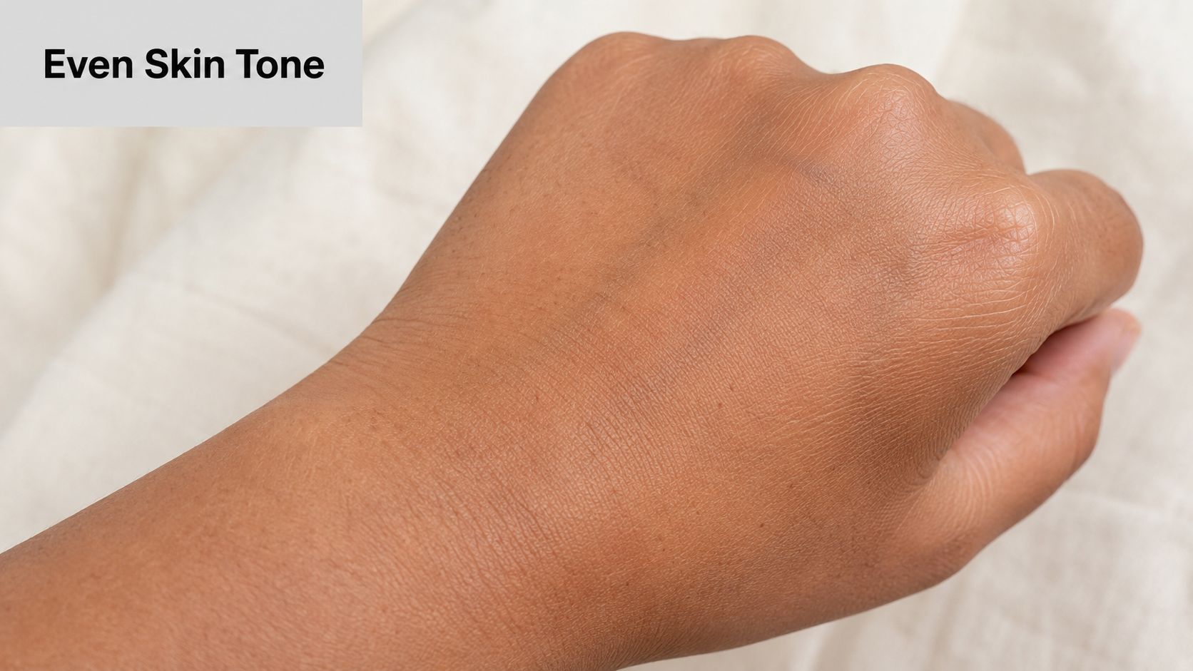 A close-up view of an even, smooth, and healthy-looking brown skin tone on a person's hand.
