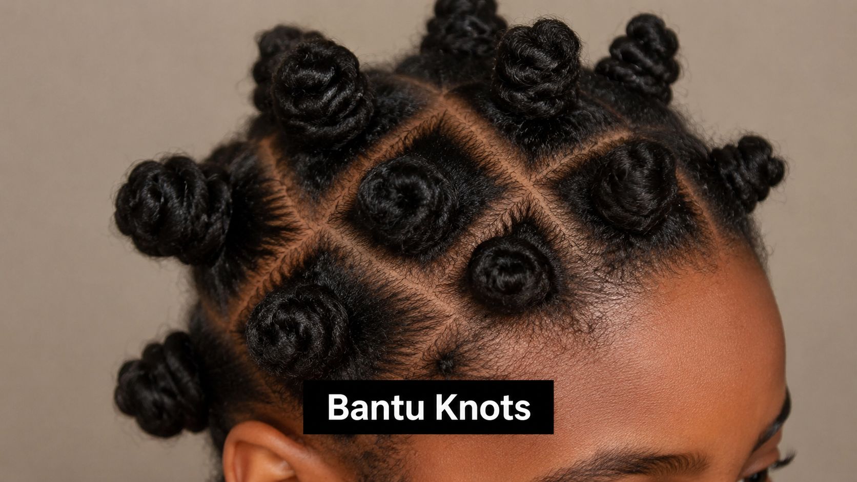 A close-up view of a person with afro-textured hair styled into neat and uniform Bantu knots.