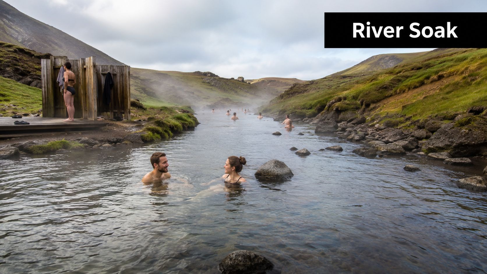 A couple enjoying the natural thermal river at Reykjadalur valley in Iceland with other bathers nearby.